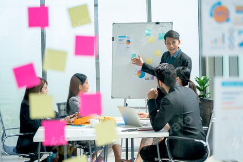 Preview: Look through transparent board of Asian business man present the project on whiteboard to co-workers