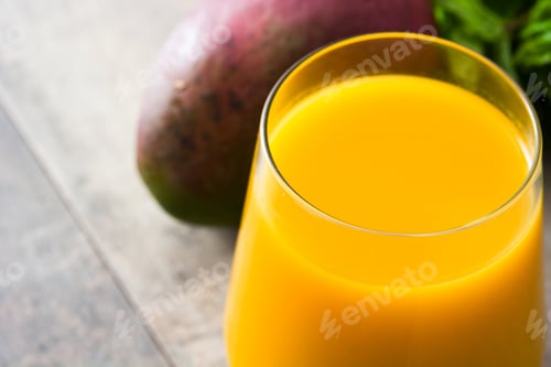 Preview: Fresh mango juice with ripe mango fruit on wooden table