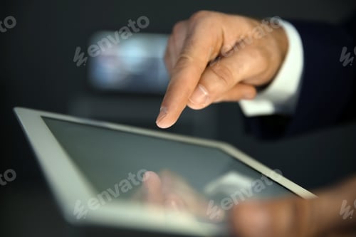 Preview: Businessman using digital tablet at workplace, closeup of hand. Mockup for design
