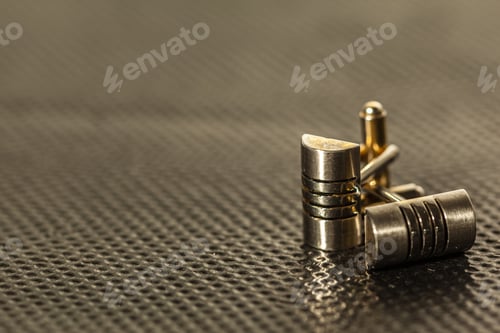 Preview: Display of metal clips on a textured surface in close-up view during daylight