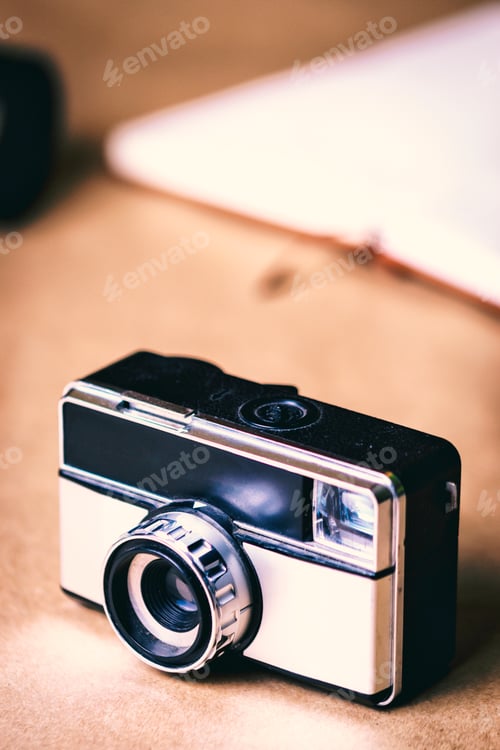 Preview: Gray vintage photo camera with brown background.