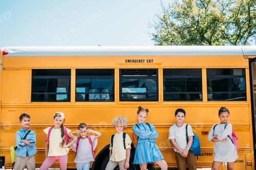Preview: group of happy scholars posing in front of school bus