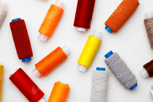 Preview: Colored spools of threads on white background