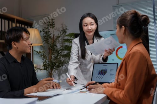 Preview: Asian businesspeople discussing and analyzing financial graphs during a meeting