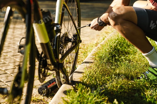 Preview: Young white cyclist inflating tire while working out