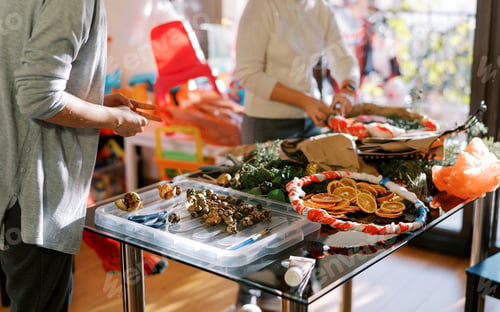 Preview: Designers at the table make New Year wreaths. Cropped