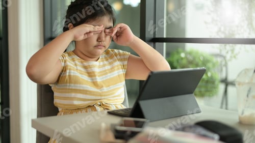 Preview: Asian child girl closes her eyes to rest from using tablet, eyes problems from using tablet.