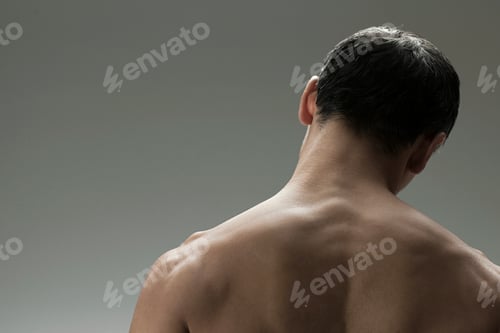 Preview: A serene back view of a shirtless man against a neutral backdrop