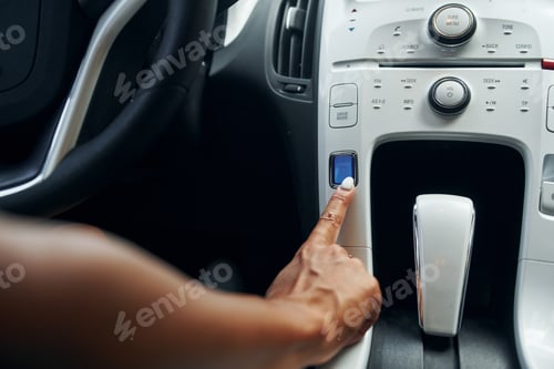Preview: Woman in casual clothes is sitting in her automobile at daytime