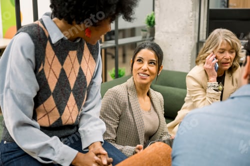 Preview: Diverse women coworkers collaborating and discussing in office lounge