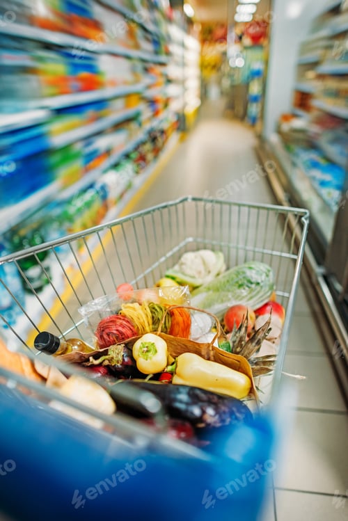 Preview: selective focus of shopping cart with purchases in supermarket