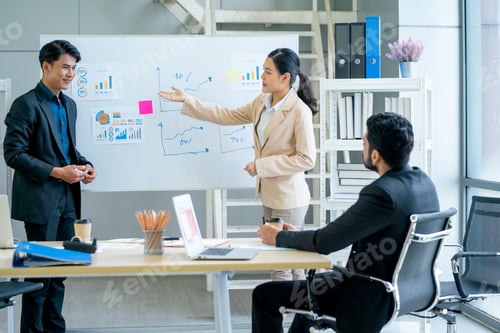 Preview: Asian business man and woman stand in front board to present the project for manager in office