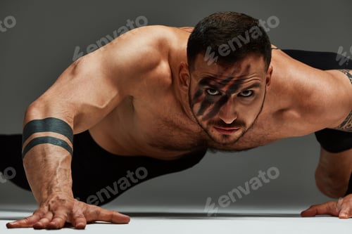 Preview: Man Doing Push-Up with Black Paint on Face