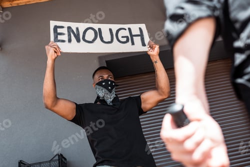 Preview: selective focus of african american man with scarf on face holding placard with enough lettering