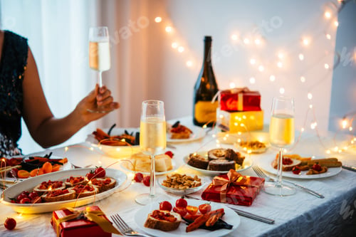 Preview: Friends hand in gifts at a party table celebrating Christmas or New Year.