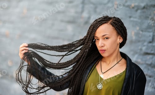 Preview: Portrait of an attractive young woman with beautiful braids posing outdoors
