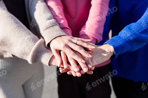 Preview: close-up of three friends' hands clasped