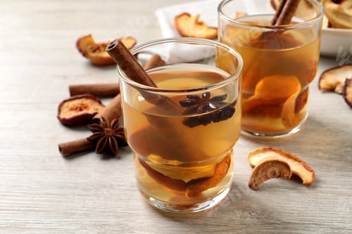 Preview: Delicious compote with dried apple slices, anise and cinnamon on white wooden table