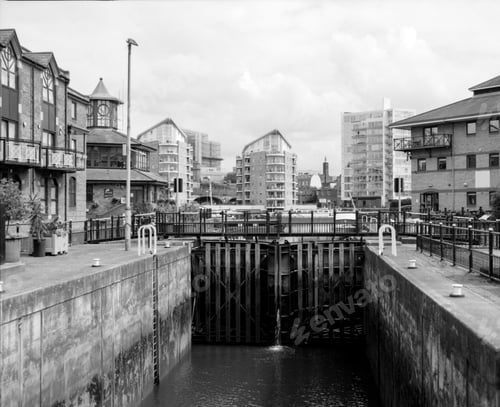 Preview: Water flowing into canal lock in urban setting, grainy black and white film photography