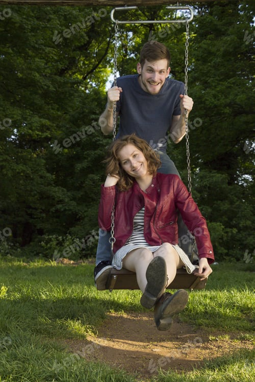 Preview: Cute Girl And Boy, On A Swing, Holding Hands.