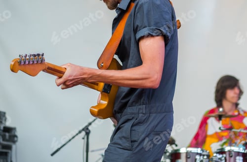 Preview: Man with guitar playing on stage during concert or music festival