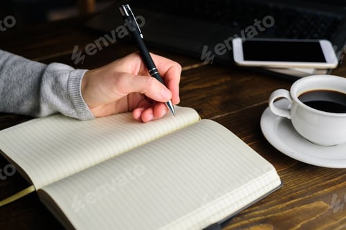 Preview: Woman writing by left hand in notebook