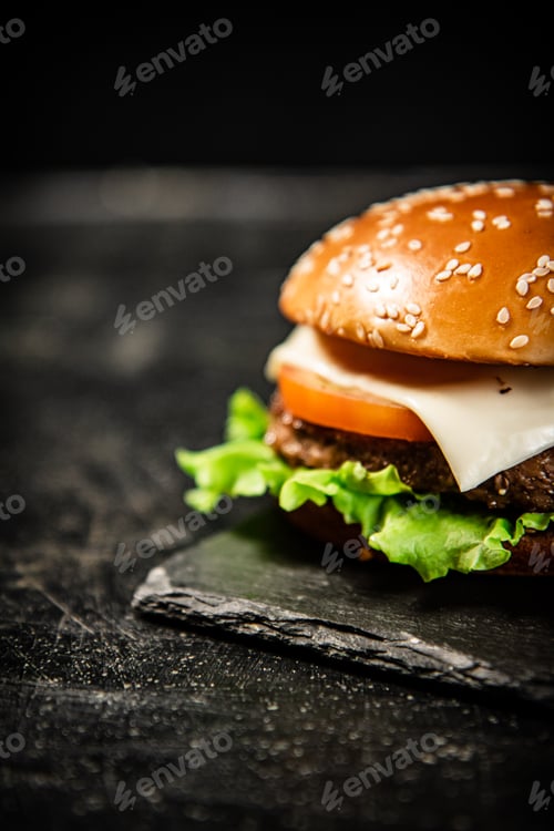 Preview: A burger on a stone board on a table.