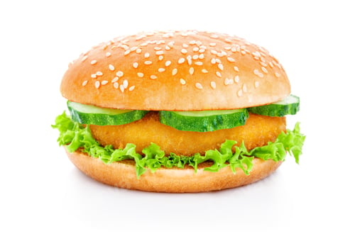Preview: Crispy chicken burger with fresh lettuce and sliced cucumbers served on a sesame seed bun