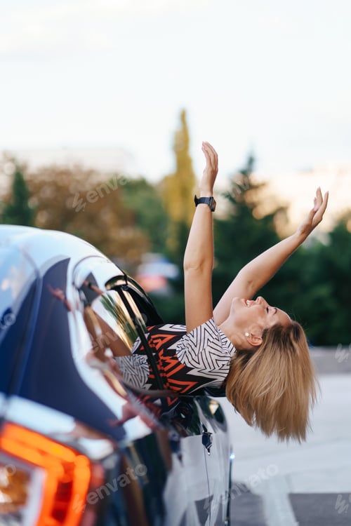 Preview: Cheerful woman coming out window of her car