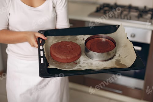 Preview: Confectioner takes the finished cake out of the oven.