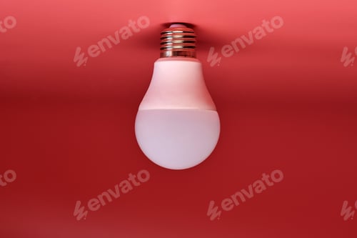 Preview: Energy saving light bulb, copy space, pink background. Minimal idea concept.