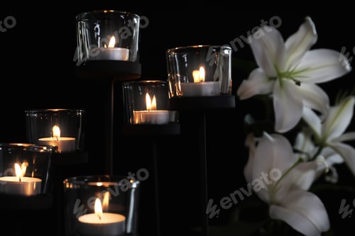 Preview: Burning candles and flowers on dark background. Funeral symbol