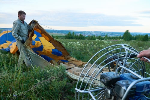 Preview: Young Caucasian Man Preparing Paraglider Canopy for Powered Paragliding Flight