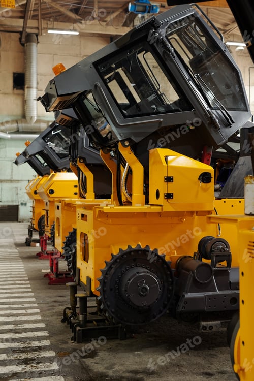 Preview: Several huge construction machines of yellow color standing in row
