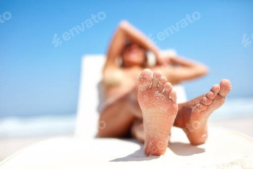 Preview: Relaxing on the beach. A beautiful, young woman relaxing at the beach.