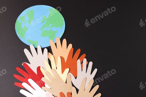 Preview: Paper cut out of multi coloured hands and globe with copy space on black background