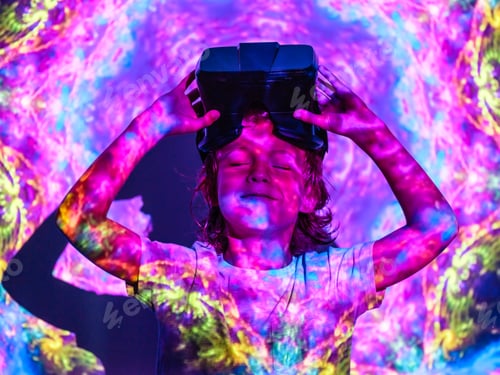 Preview: Smiling boy with VR headset under projector light