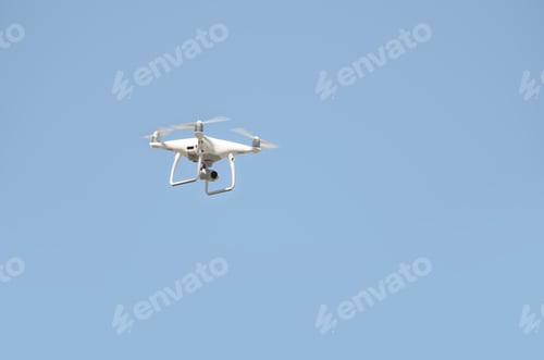 Preview: Big white drone hovering in a bright cloudless blue sky