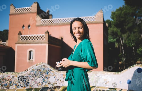 Preview: Joyful ethnic woman with camera on stroll