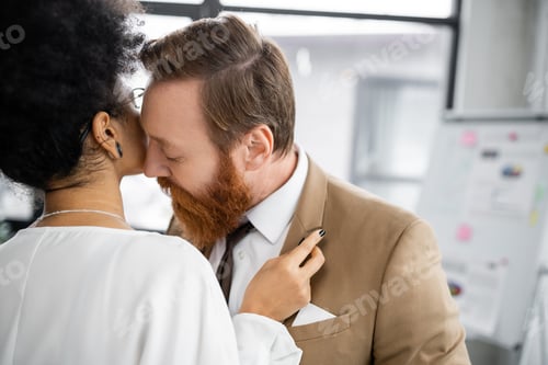 Preview: seductive african american woman adjusting blazer of bearded businessman in formal wear