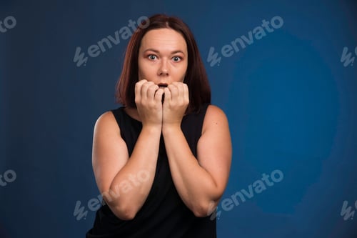 Preview: Woman with worried expression on a dark background
