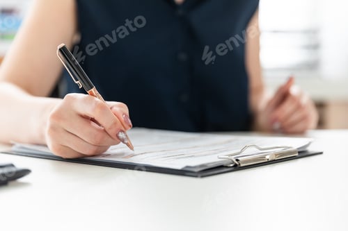 Preview: Woman Writes on Documents on a White Desk