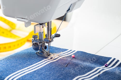 Preview: Sewing machine with striped blue white fabric and thread, home crafting or hobby, horizontal