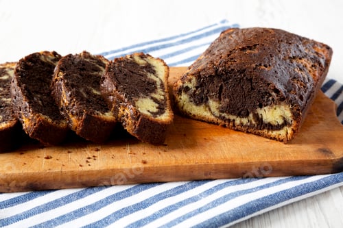 Preview: Homemade Chocolate and Vanilla Marble Cake on a rustic wooden board, side view. Close-up.