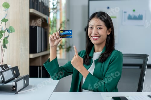 Preview: A woman is holding a credit card and smiling