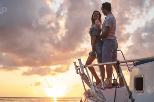 Preview: Beautiful couple looking at sunset from the yacht