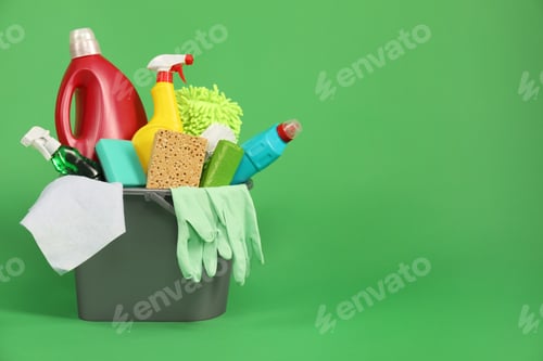 Preview: Different cleaning products in bucket on green background, space for text