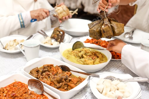 Preview: Cropped shot of woman hand serving ketupat lebaran