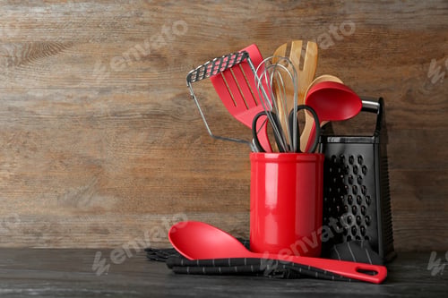 Preview: Holder with kitchen utensils on table against wooden background. Space for text