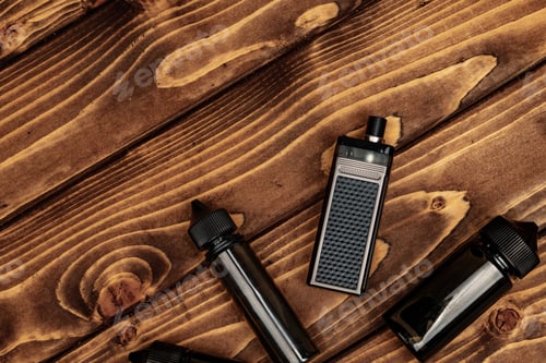 Preview: Vape and vape juice bottles on brown wooden background